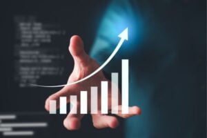 fundsforNGOs - 2026-06-05T153546013 - Funds for Companies Hand reaching toward a rising bar chart with an upward arrow, symbolizing growth or increasing metrics